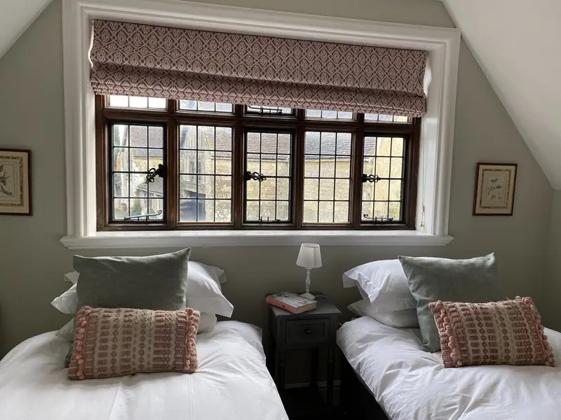 A quiet twin bedroom with a mullioned window at Hinton St Mary